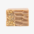 Three stacked bars of oatmeal soap on a white background