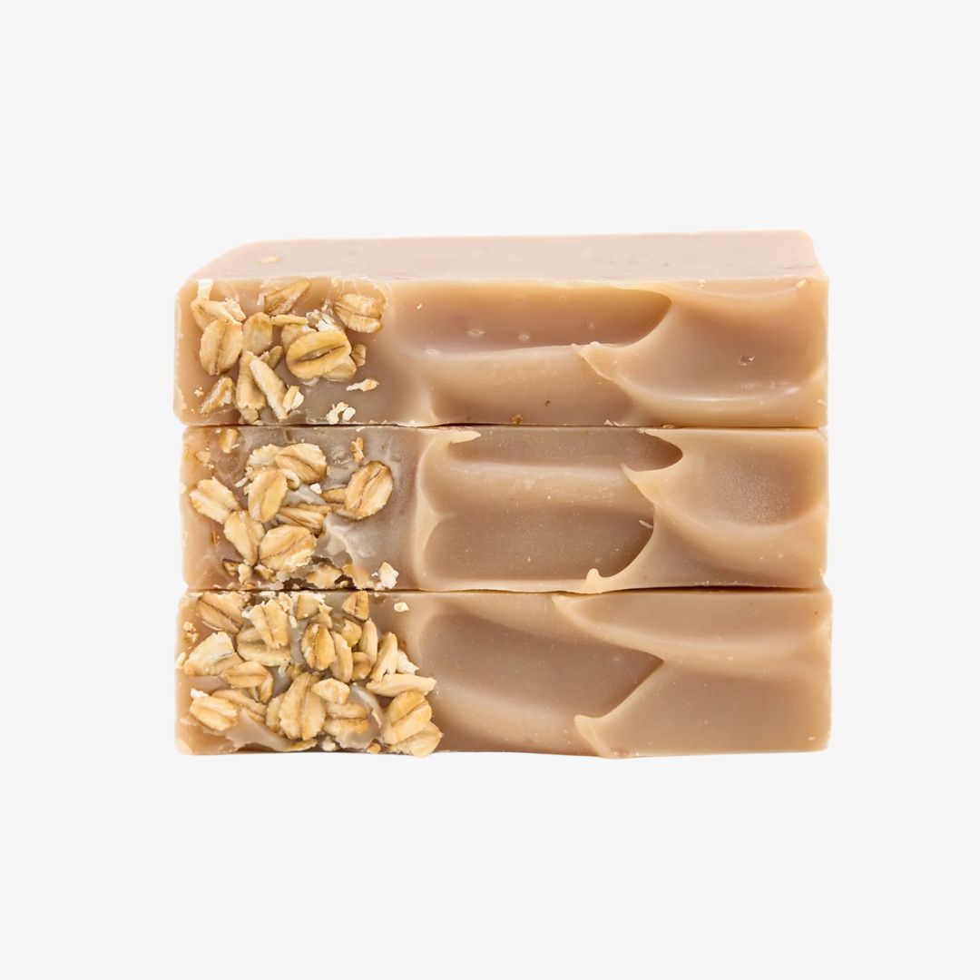 Three stacked bars of oatmeal soap on a white background