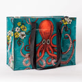 A rectangular shoulder tote bag with black handles, featuring a large red octopus with swirling tentacles against a teal background, surrounded by yellow and white flowers.