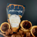 Pecan pie butter tart caramels with a package labeled 'Jickle and Jiggle' on a wooden board.
