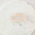 Pink hair clip on a marble surface