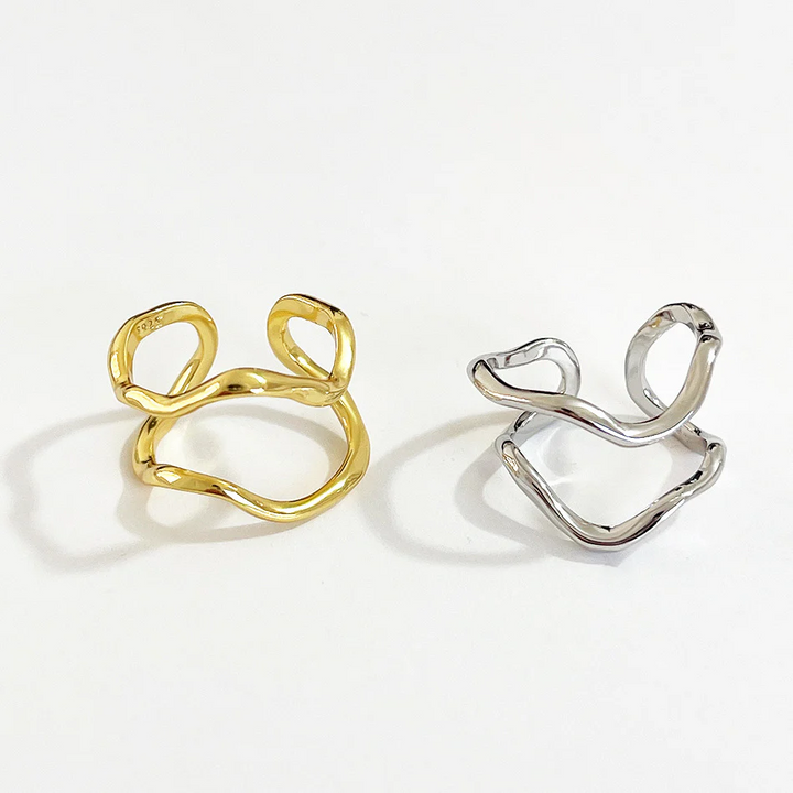 Two organic shaped adjustable rings, one in sterling silver and one in gold plating, featuring a fluid, abstract, double wave design, displayed on a white background. These modern rings are available in Ottawa, Ontario, Canada.