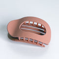 Pink hair clip on a light gray background