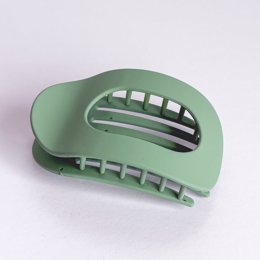 Green plastic clip on a white background