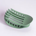 Green soap dish on a light purple background