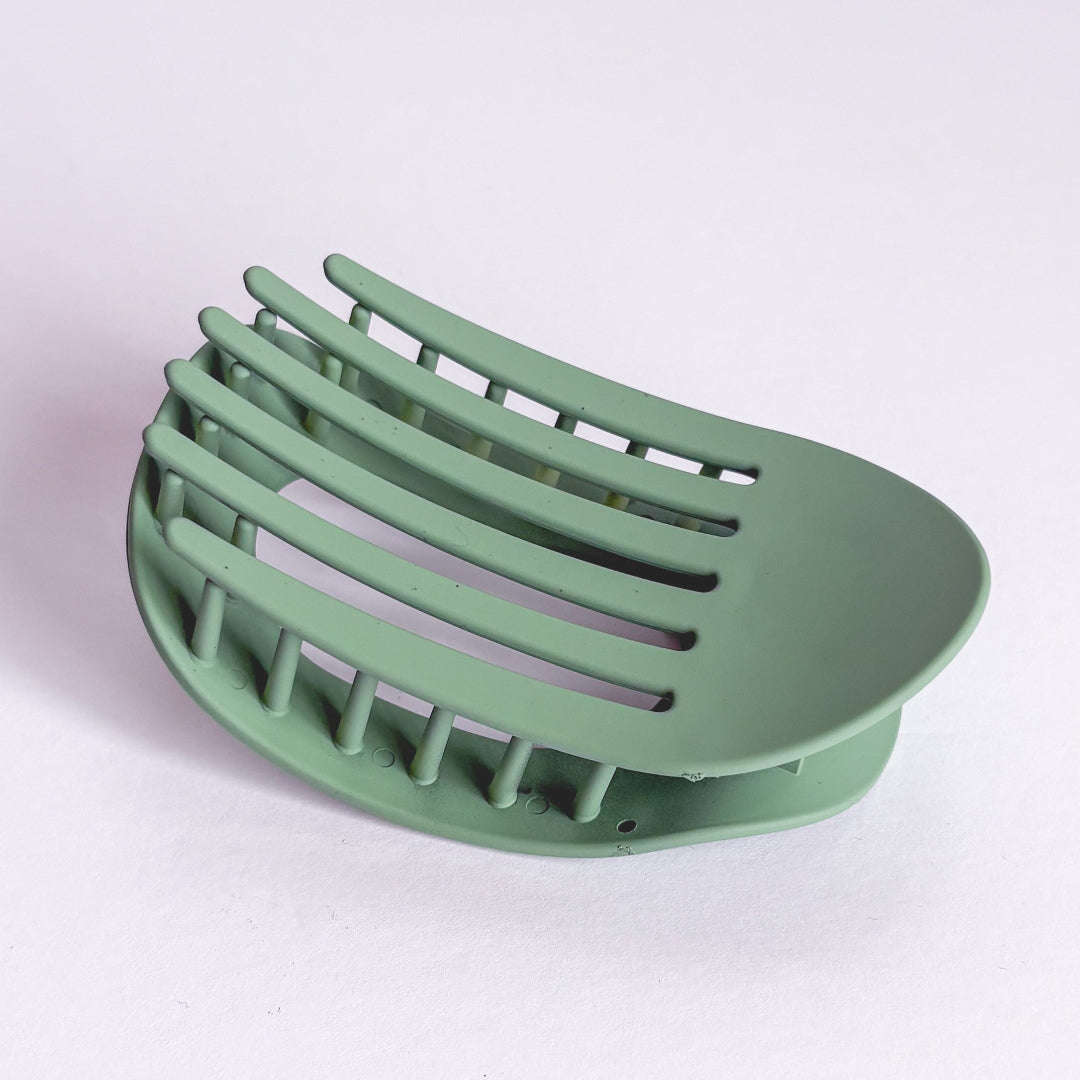 Green soap dish on a light purple background