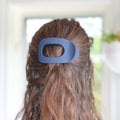 Blue hair clip in a person's hair with a blurred background