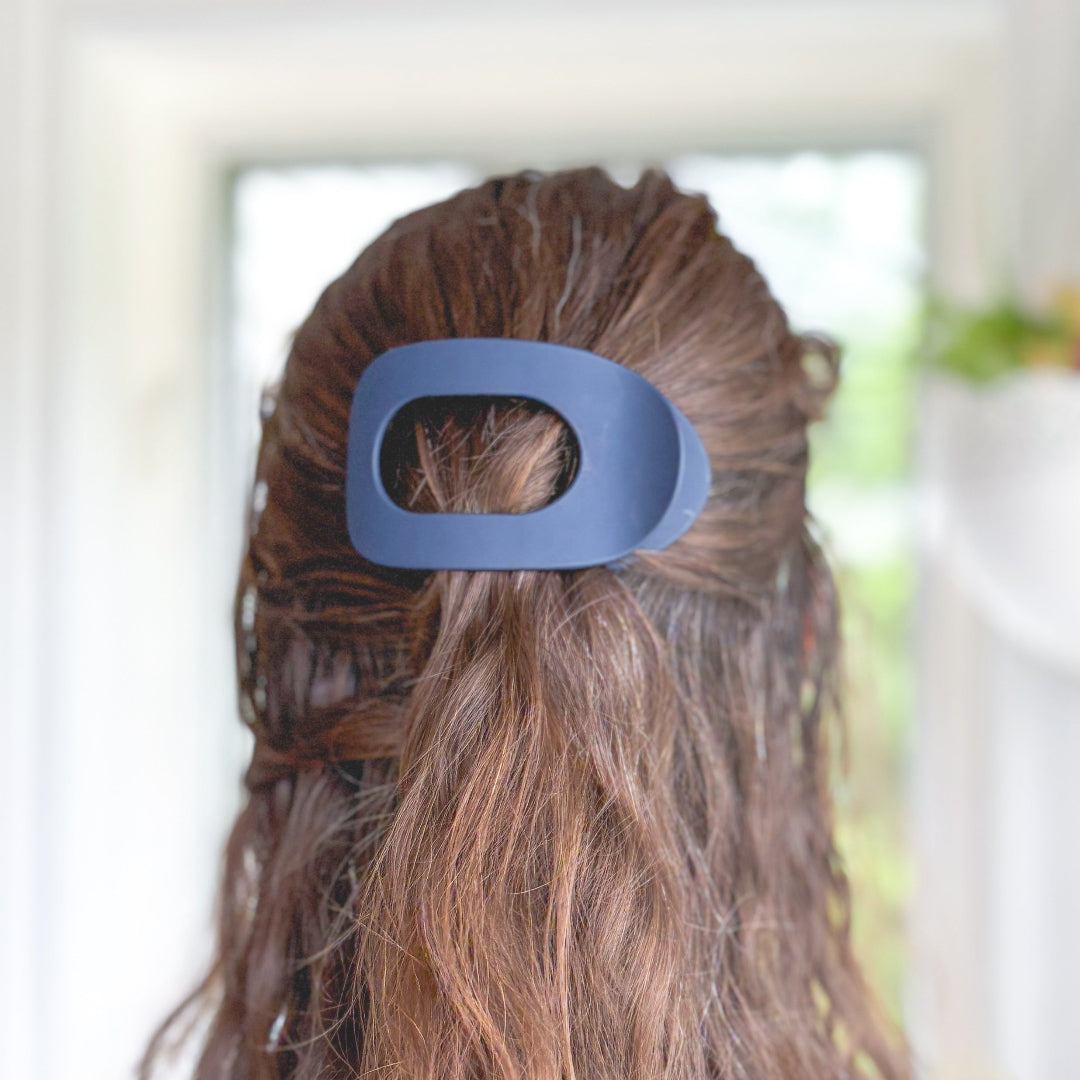 Blue hair clip in a person's hair with a blurred background