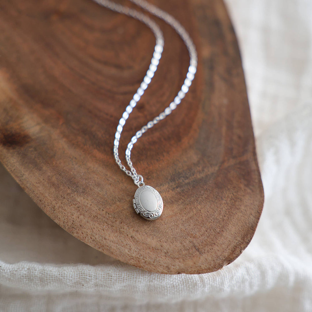 Silver necklace with a pendant on a wooden surface
