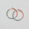 A pair of delicate 14 KT gold hoop earrings, each partially threaded with small Japanese glass seed beads in a pattern of light blue, white, black, and coral. The beads cover approximately half of each hoop, leaving the remaining gold wire visible.