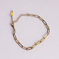 Gold chain bracelet on a light gray background