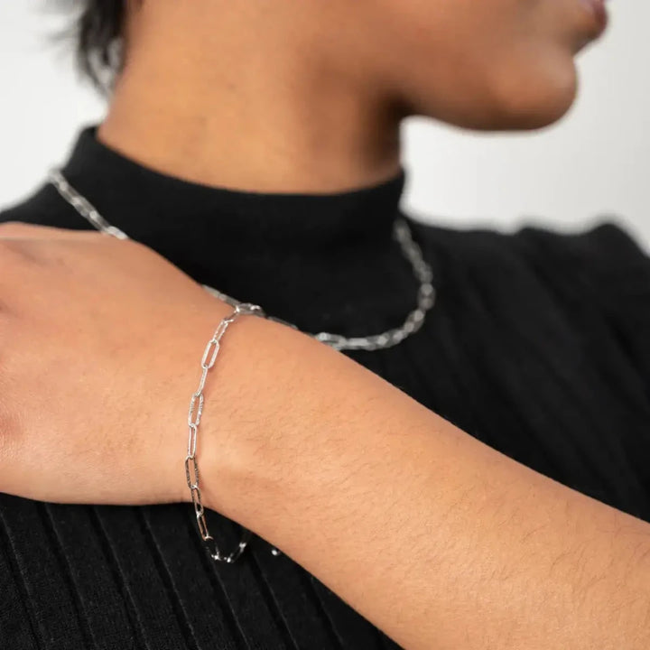  A bracelet is silver-coloured have a chain link design made of small, rectangular links.