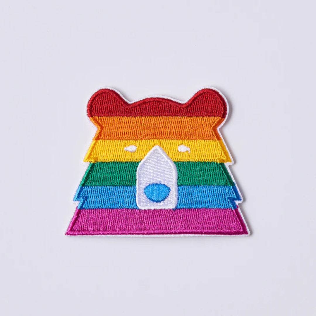 Colorful embroidered patch with a bear design on a light gray background