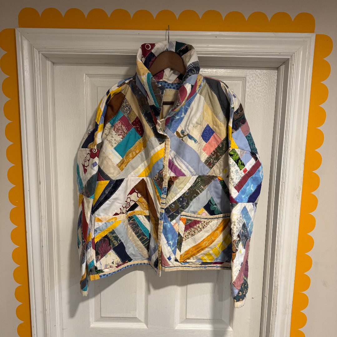 Colorful quilt draped over a white door with decorative yellow trim.