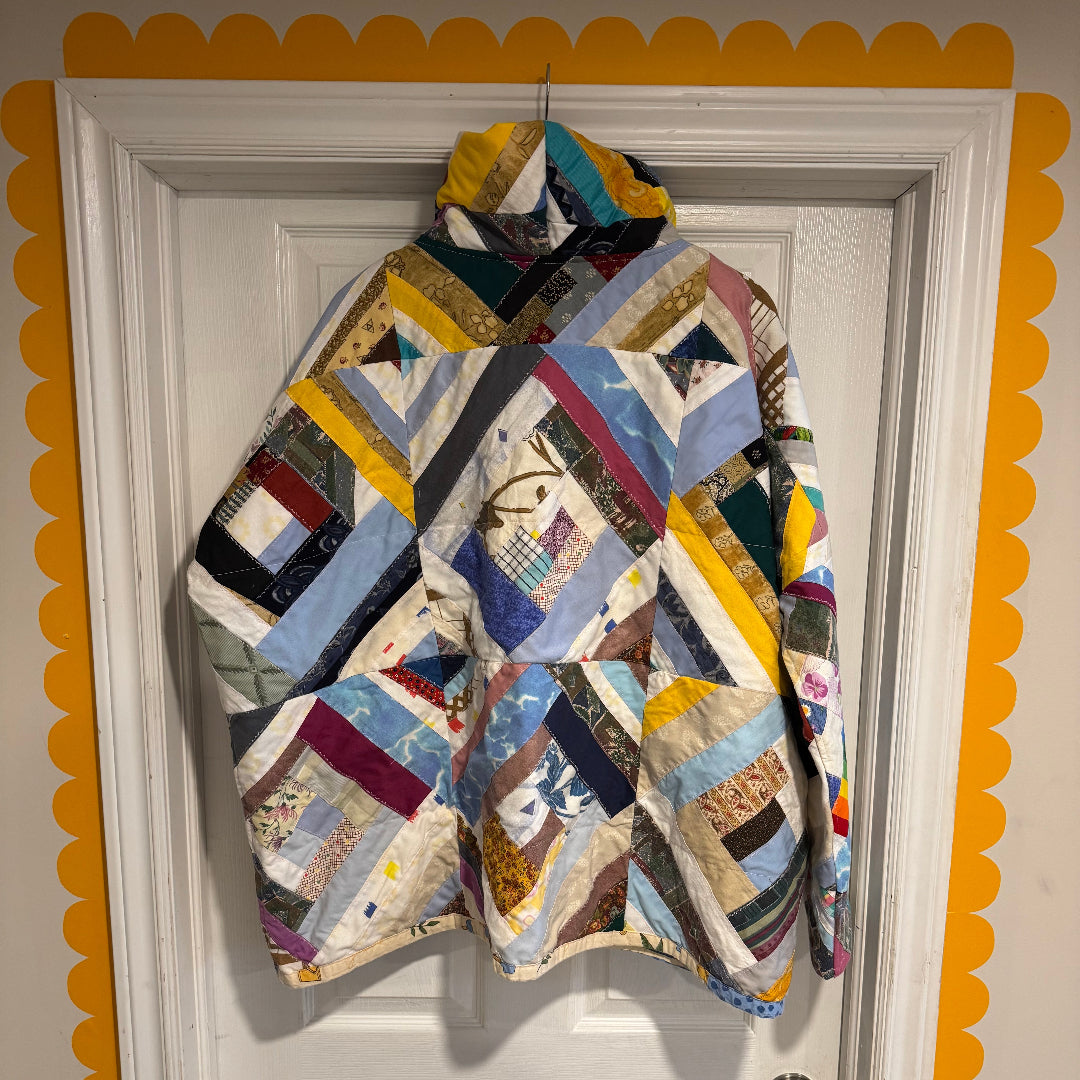 Colorful patchwork quilt draped over a white door with decorative yellow trim.