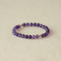 Purple beaded bracelet on a beige background