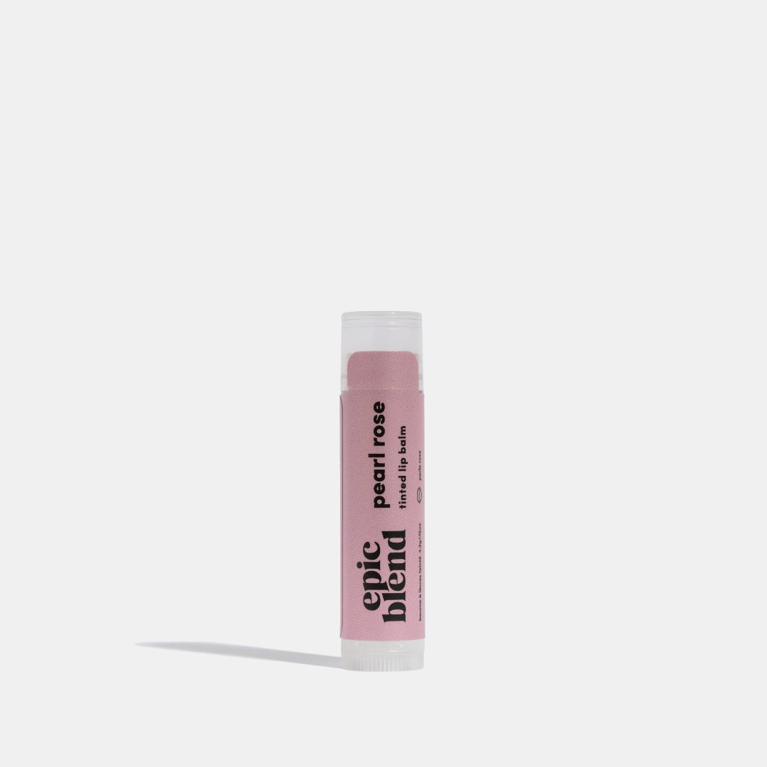 A white tube of Epic Blend Pearl Rose Tinted Lip Balm with a light pink label. The label displays the brand name, "pearl rose tinted lip balm," and indicates it has a subtle tint and shimmer.