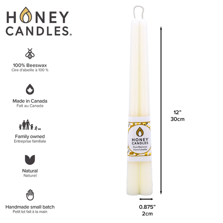 Two cream-colored beeswax candles are standing upright, tied together with a string. The candles have a label that says 