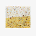 Soap bar with speckled texture and 'Soap So Co' branding on a black background