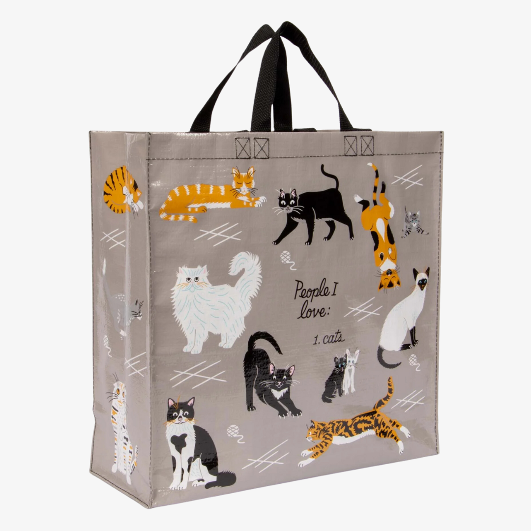 A reusable tote bag with a cat-themed design. The bag is a light grey color with black handles. It features a variety of cats in different poses and breeds, including a white fluffy cat, a black cat, a tabby cat, and a Siamese cat. The text "People I love: 1. Cats" is printed on the bag in black.