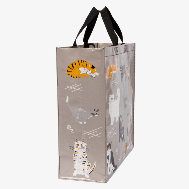 A reusable tote bag with a cat-themed design. The bag is a light grey color with black handles. It features a variety of cats in different poses and breeds, including a white fluffy cat, a black cat, a tabby cat, and a Siamese cat. The text 