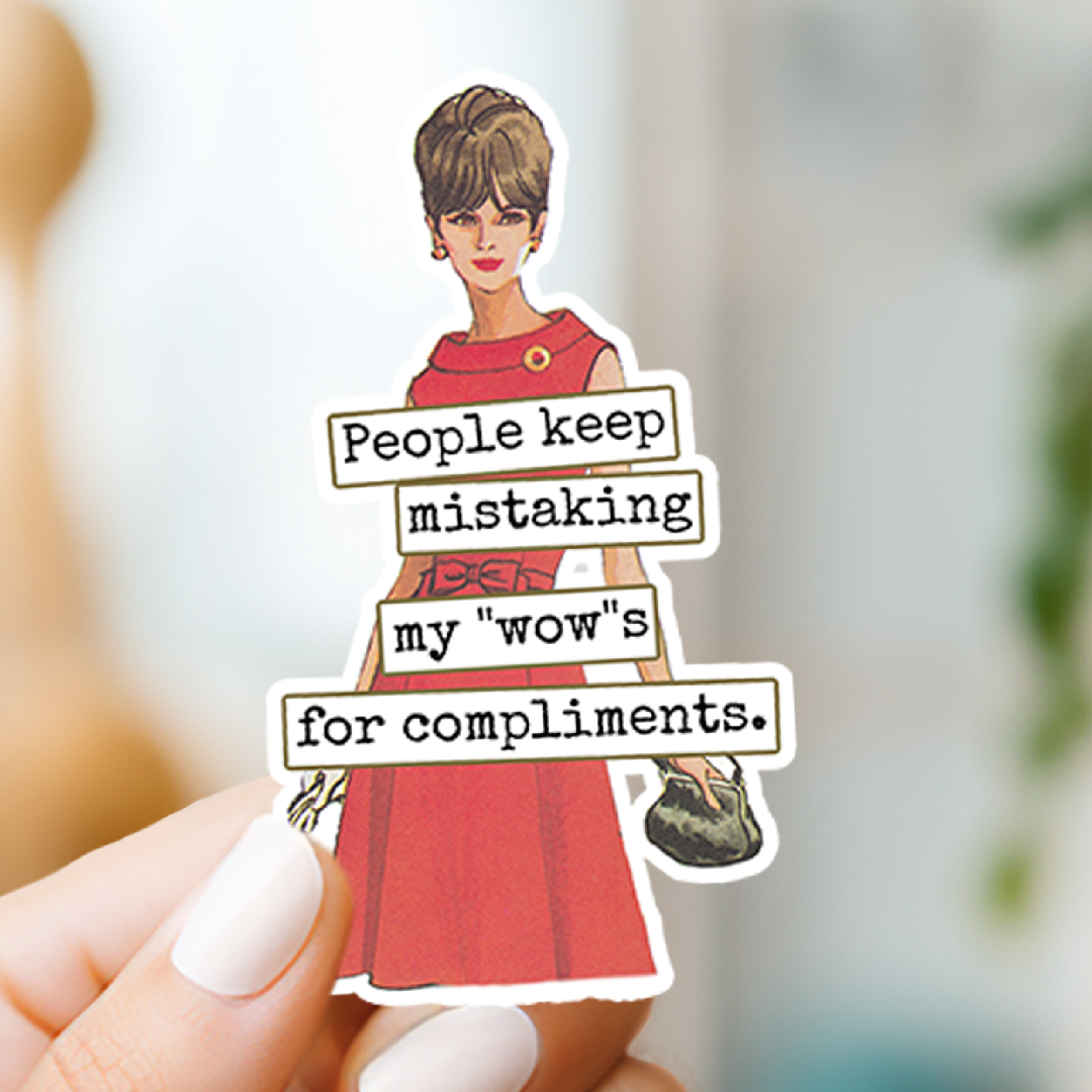 Sticker with a woman in a red dress and text held by a hand against a blurred background