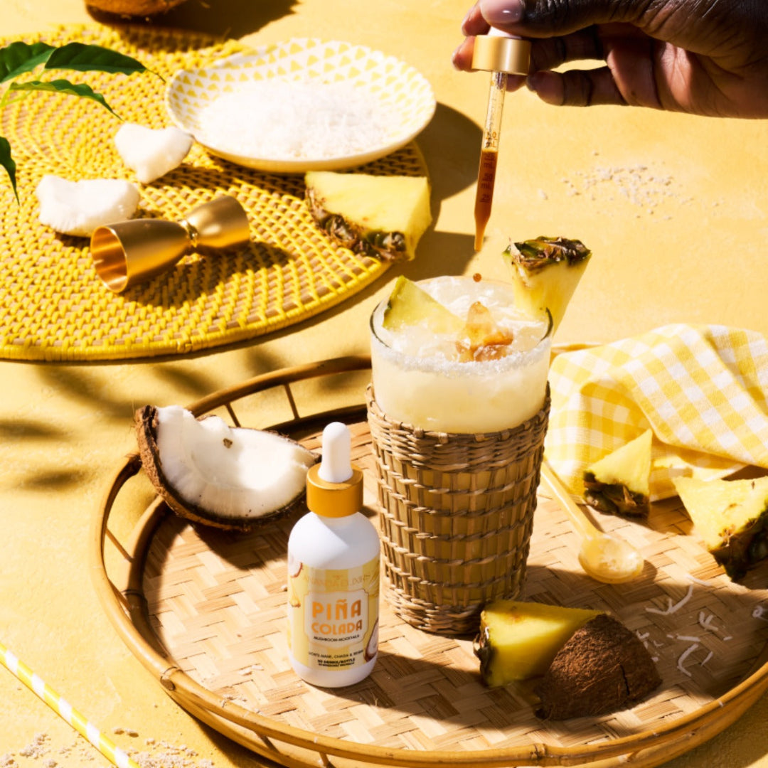 Pina Colada being prepared with a bottle of Pina Colada on a yellow table.
