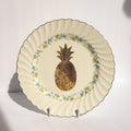 Decorative plate with a gold pineapple design on a white background