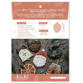 Kirkie Christmas ornament embroidery kit in its original packaging, featuring a peach and white card with product details, a size diagram, and photos of completed embroidered ornaments including Santa Claus, a gingerbread man, and a pinecone ornament.