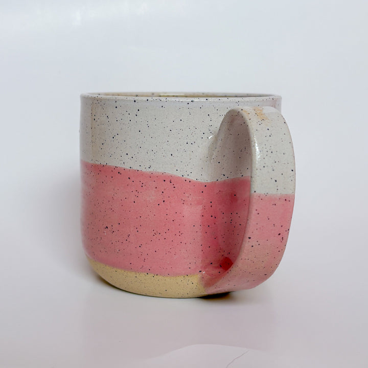 Valerie Daoust Ceramics Pink Dipped Mug, a handmade ceramic mug with a colorblock design featuring a light gray top and a speckled pink middle section, displayed on a light gray background. The mug has a large, rounded handle, a speckled texture, and is made in Mississippi Mills, Ontario, Canada.
