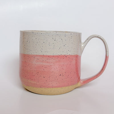 Valerie Daoust Ceramics Pink Dipped Mug, a handmade ceramic mug with a colorblock design featuring a light gray top and a speckled pink middle section, displayed on a light gray background. The mug has a large, rounded handle, a speckled texture, and is made in Mississippi Mills, Ontario, Canada.