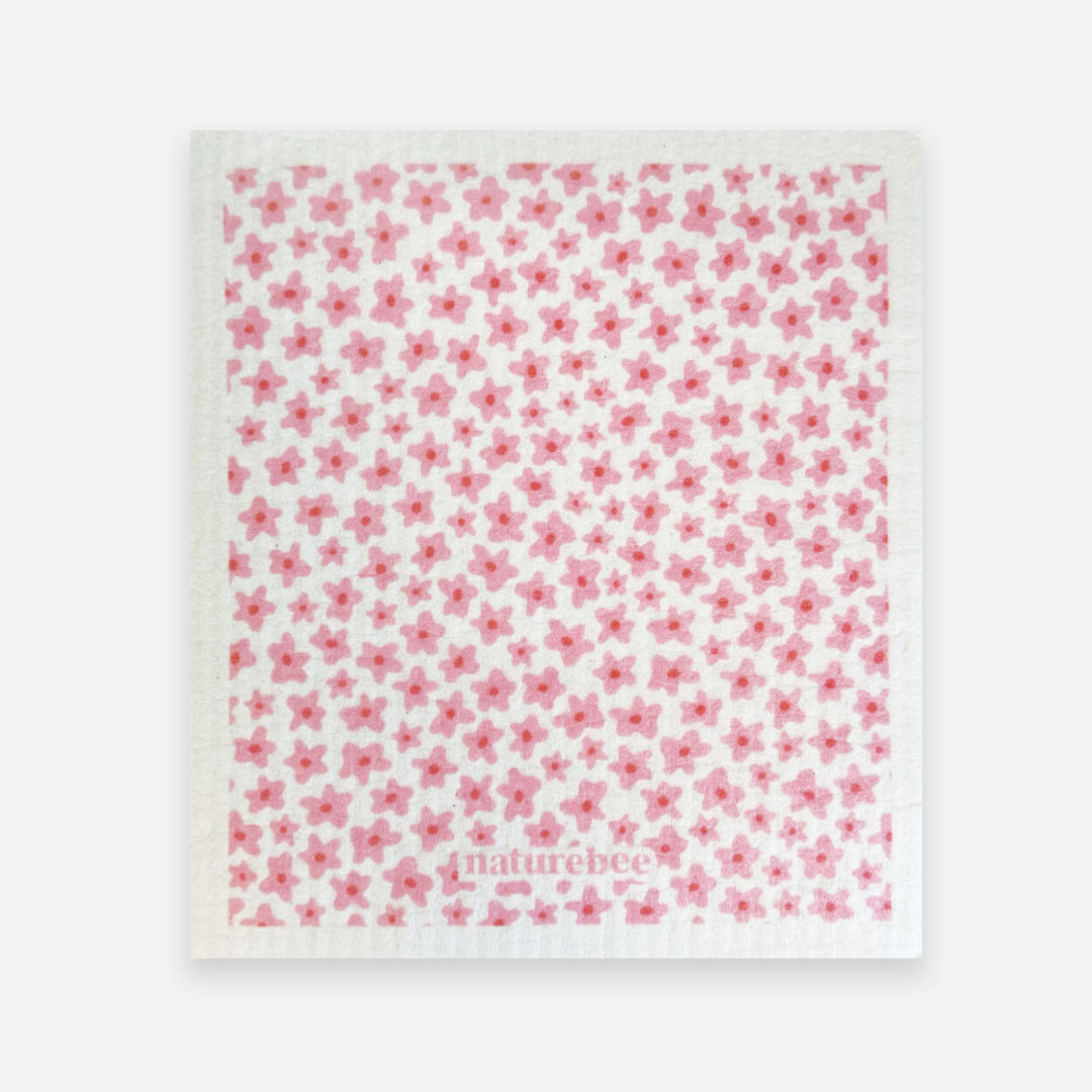 White towel with pink floral pattern and 'naturebee' branding on a white background