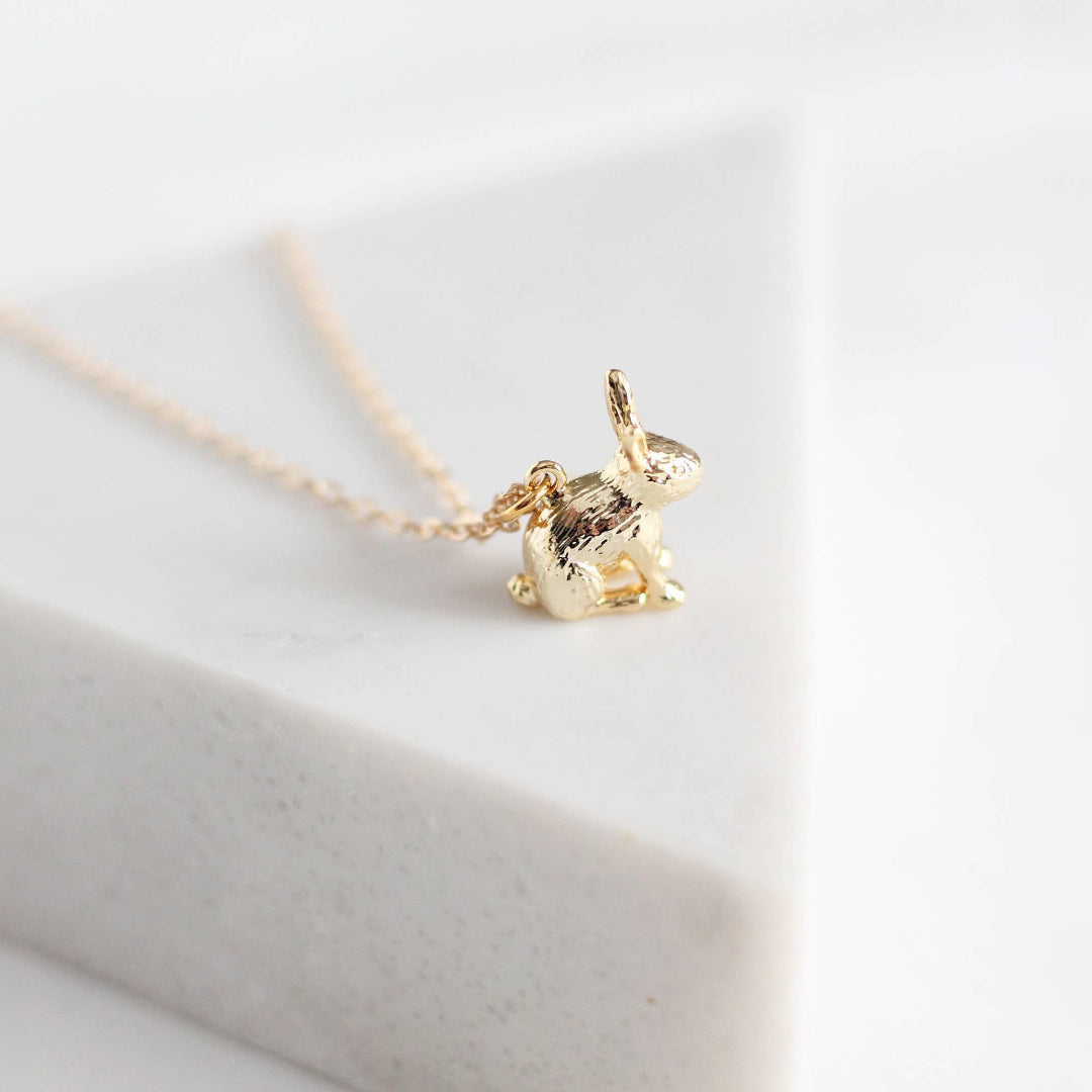 Gold bunny pendant necklace on a white background