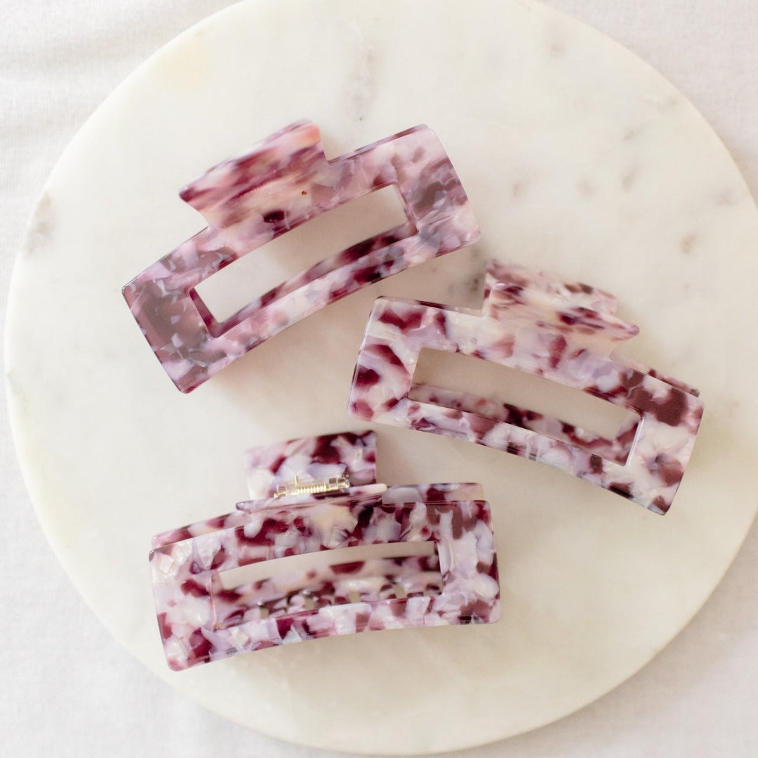 Five rectangular soap bars with a marbled pattern on a round marble slab.
