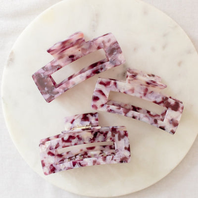 Five rectangular soap bars with a marbled pattern on a round marble slab.