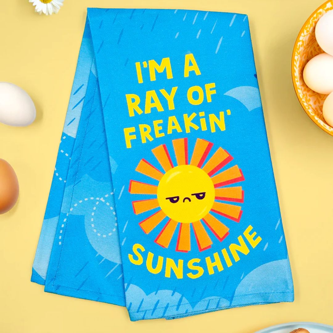 Blue towel with sun design and text on a yellow background