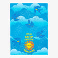 Towel with blue birds and a sun graphic on a blue background