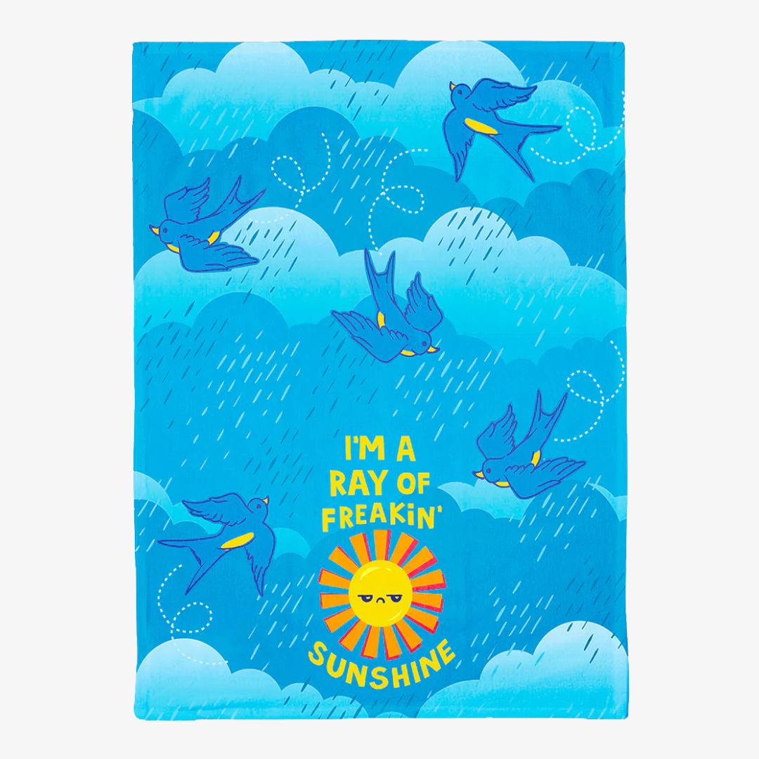 Towel with blue birds and a sun graphic on a blue background