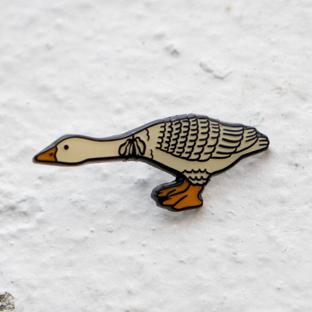 Geese-shaped pin on a textured white background