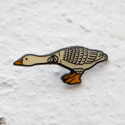 Geese-shaped pin on a textured white background
