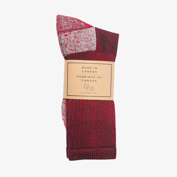 A pair of red socks rolled up and packaged with a label that reads 