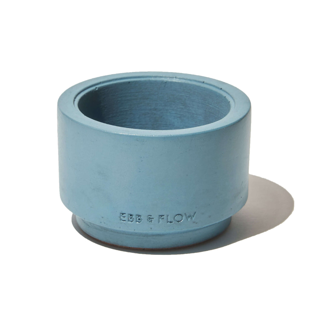 Blue cylindrical container with 'EBB & FLOW' branding on a white background