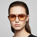 Woman wearing a pair of sunglasses with a plain background
