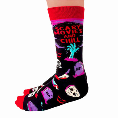 A pair of black socks with a Halloween-themed design. The socks feature a zombie hand, skulls, tombstones, and the phrase 