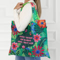 A green tote bag with a floral pattern. The text "Mostly Snacks and Random Junk I Don't Need" is printed on the bag.