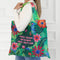 A green tote bag with a floral pattern. The text 