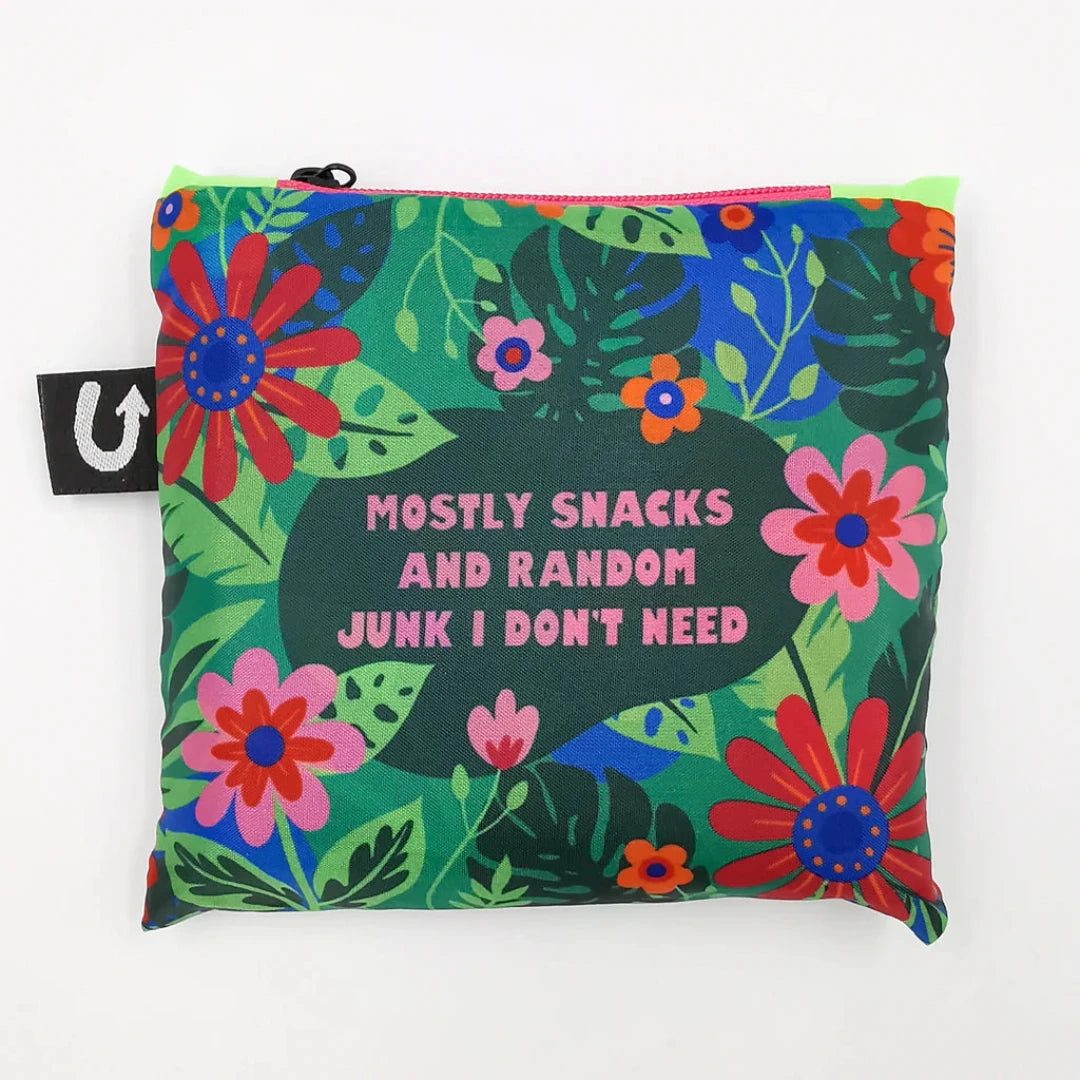 A green tote bag with a floral pattern. The text "Mostly Snacks and Random Junk I Don't Need" is printed on the bag.