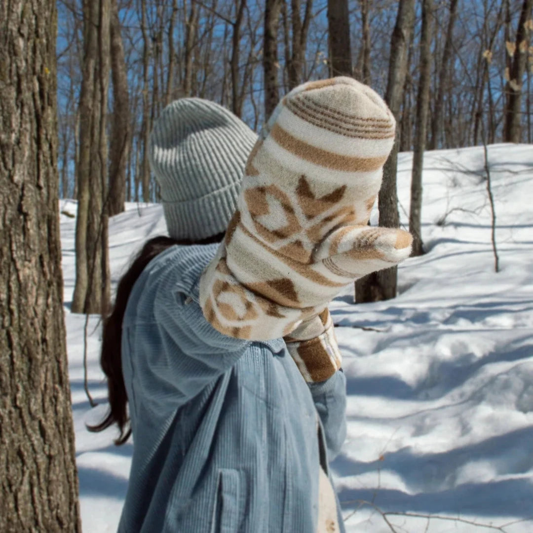 Sand Mittens, an indigenous designed mitten with a beige and blue pattern. The mittens have a wool outer layer and sherpa inner lining.