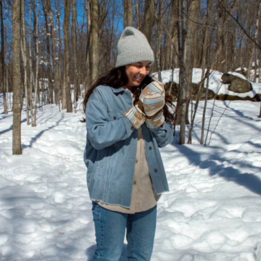 Sand Mittens, an indigenous designed mitten with a beige and blue pattern. The mittens have a wool outer layer and sherpa inner lining.