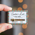 A gold-colored pin shaped like a Christmas list. The list has a slider that can be moved between "NAUGHTY" and "NICE." A star is placed on the slider.
